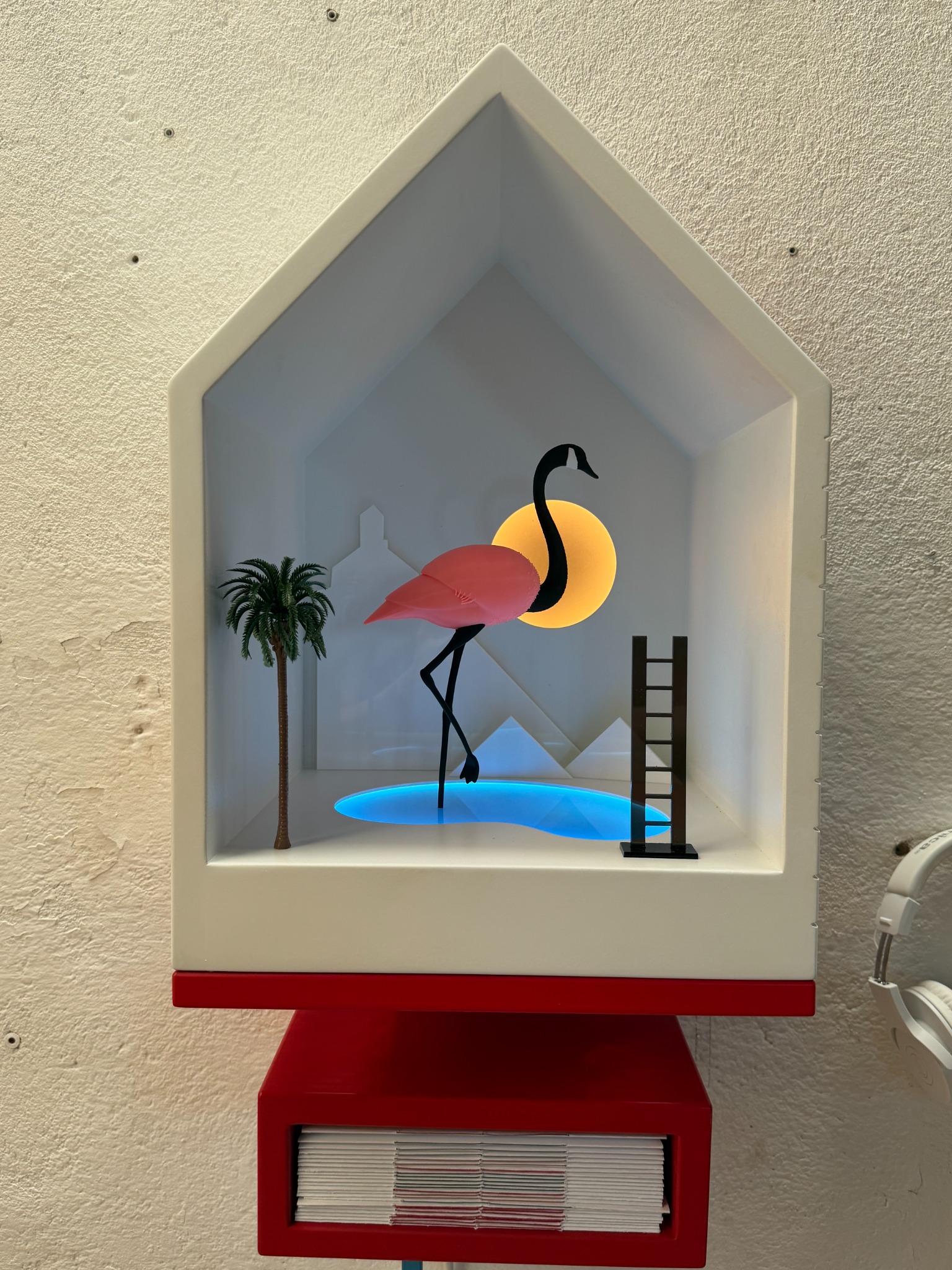 Illuminated Flamingo installation with a pink flamingo, pool, palm tree and ladder.