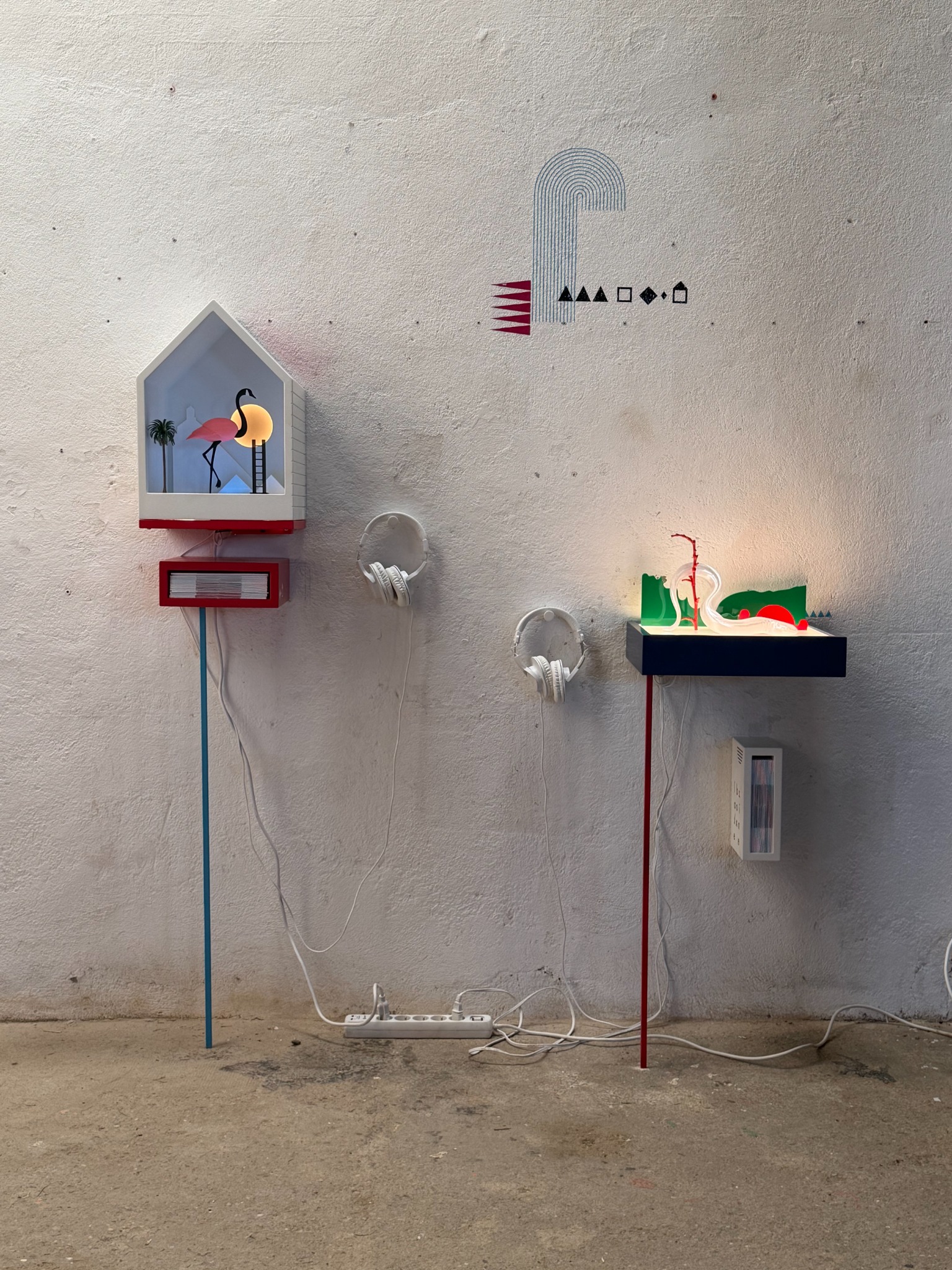 The two installation listening stations at Enchantements, with illuminated sculptural works and headphones.