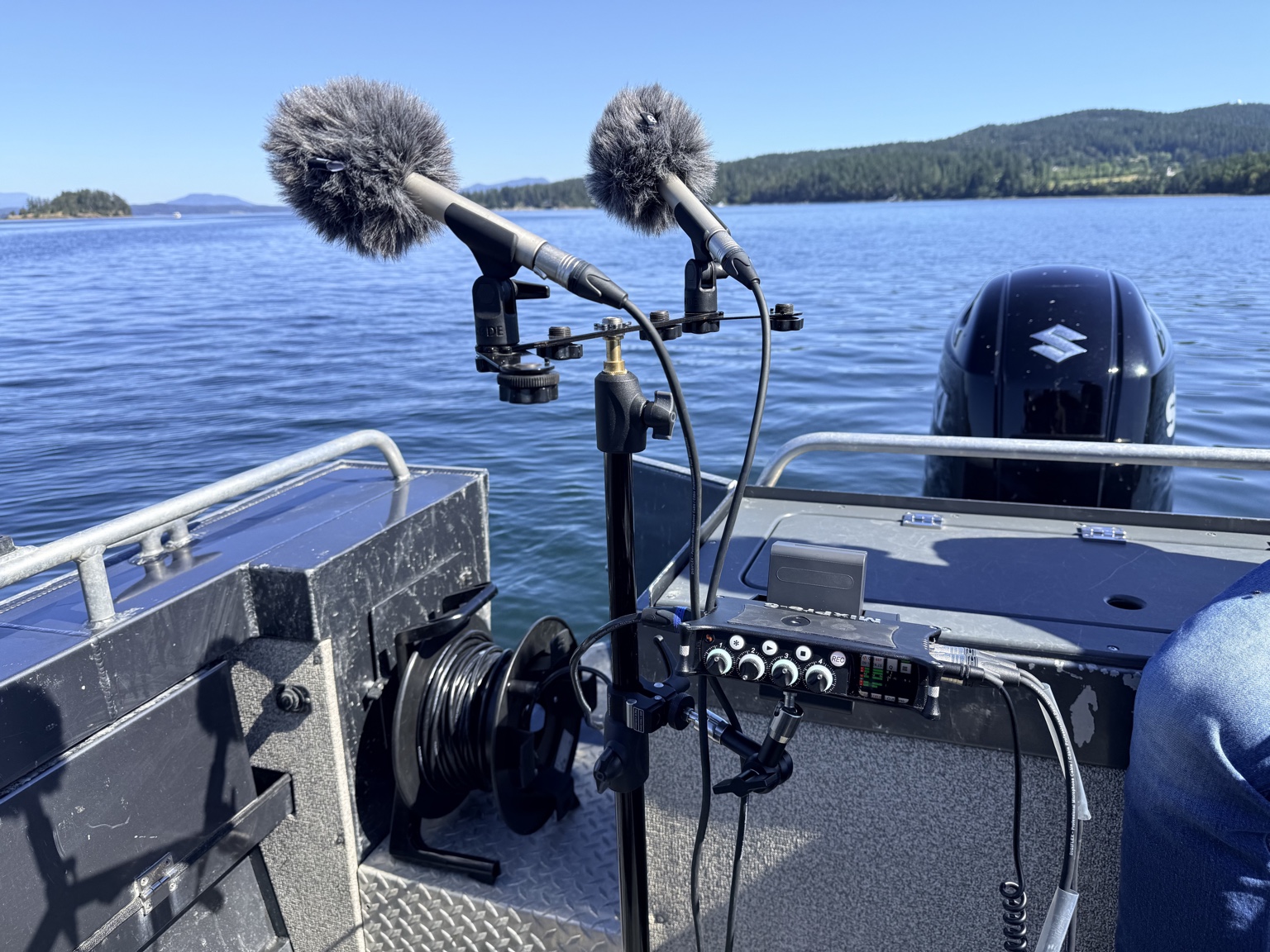Two microphones with windshields on a stereo bar above a portable audio recorder aboard a boat in Saanich Inlet.